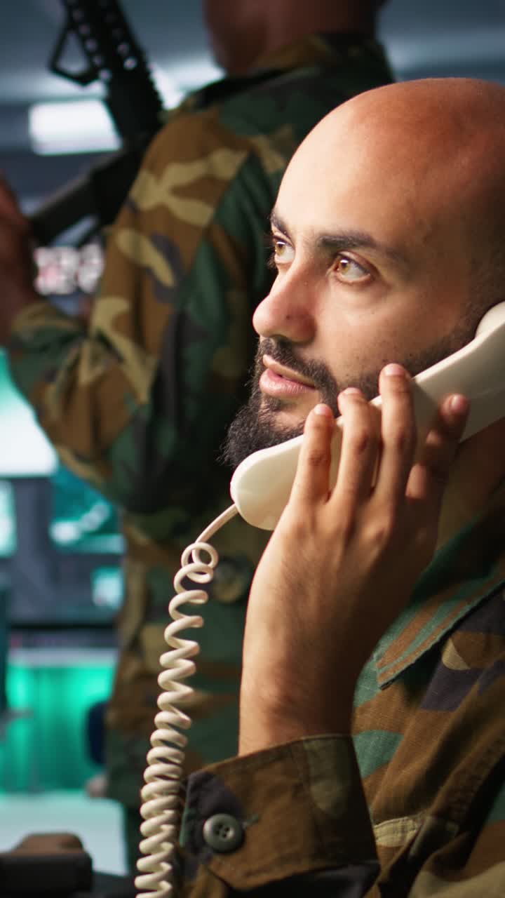 Video verticale: Soldato militare in un centro di controllo missione che risponde a una telefonata