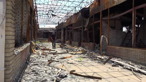 a man walks through a shopping center destroyed and burned following a russian missile attack on the city of kharkiv, ukraine