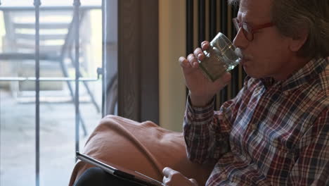 elderly man with gray-haired mustache sitting on the couch