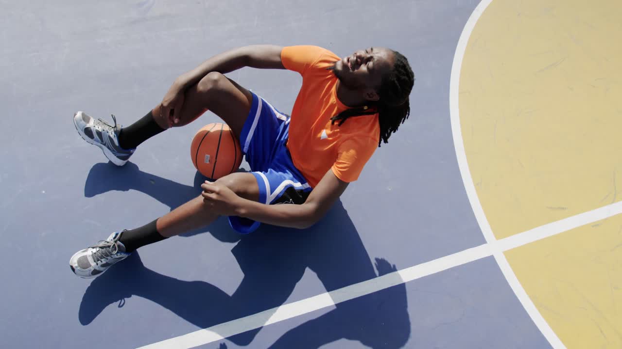 Basketball player sitting with basketball in court 4k