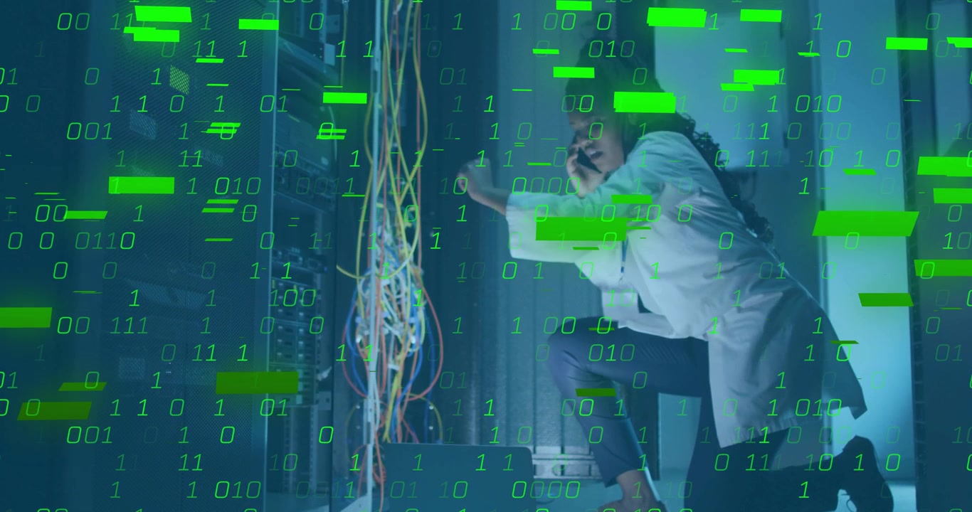 Data-center technician kneeling sorting Ethernet cables while taking call monitoring green overlay
