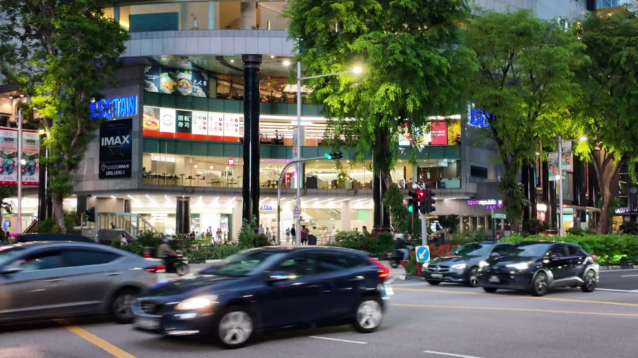Busy City Street at Night with Shopping Mall