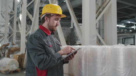 factory worker in helmet checking products