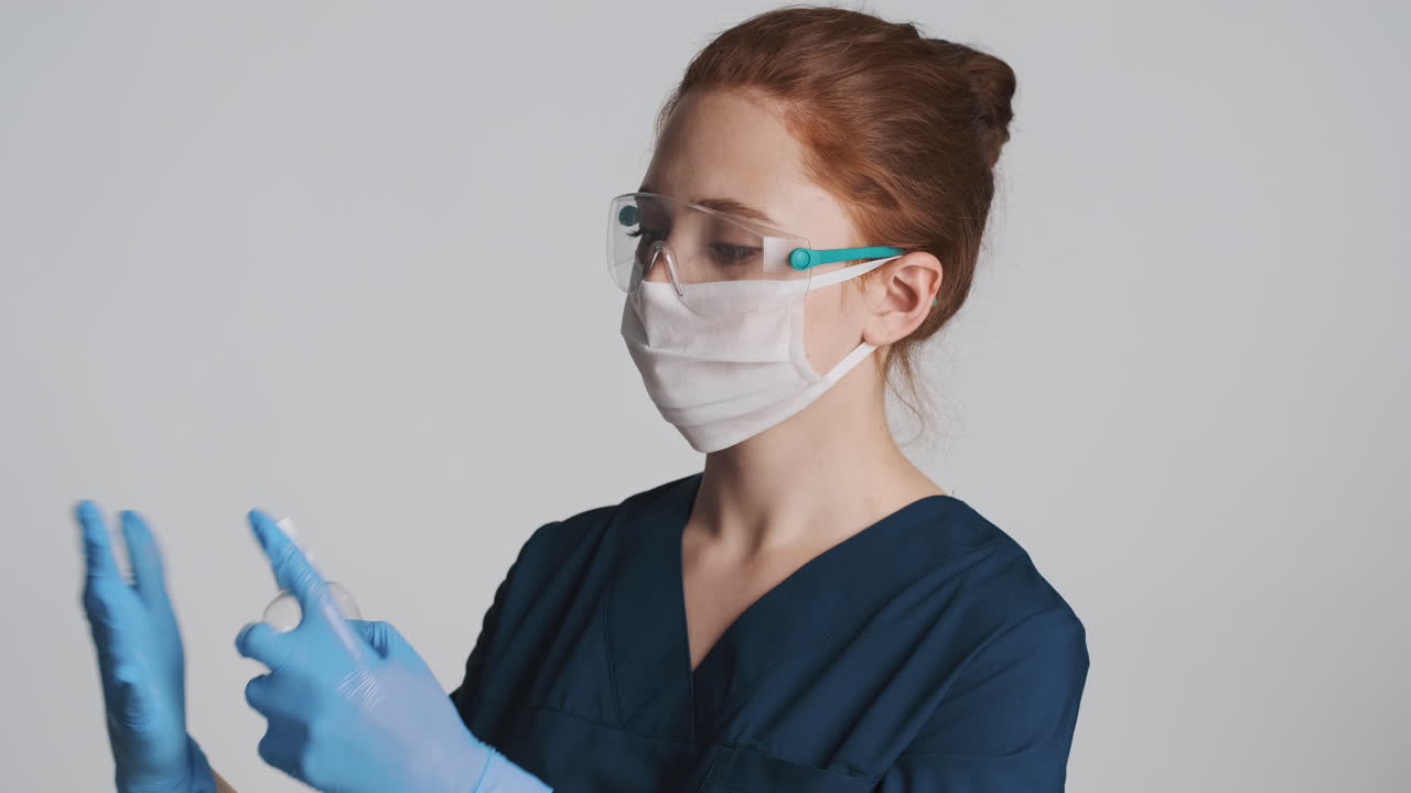 médico pelirrojo frente a la cámara sobre un fondo gris.