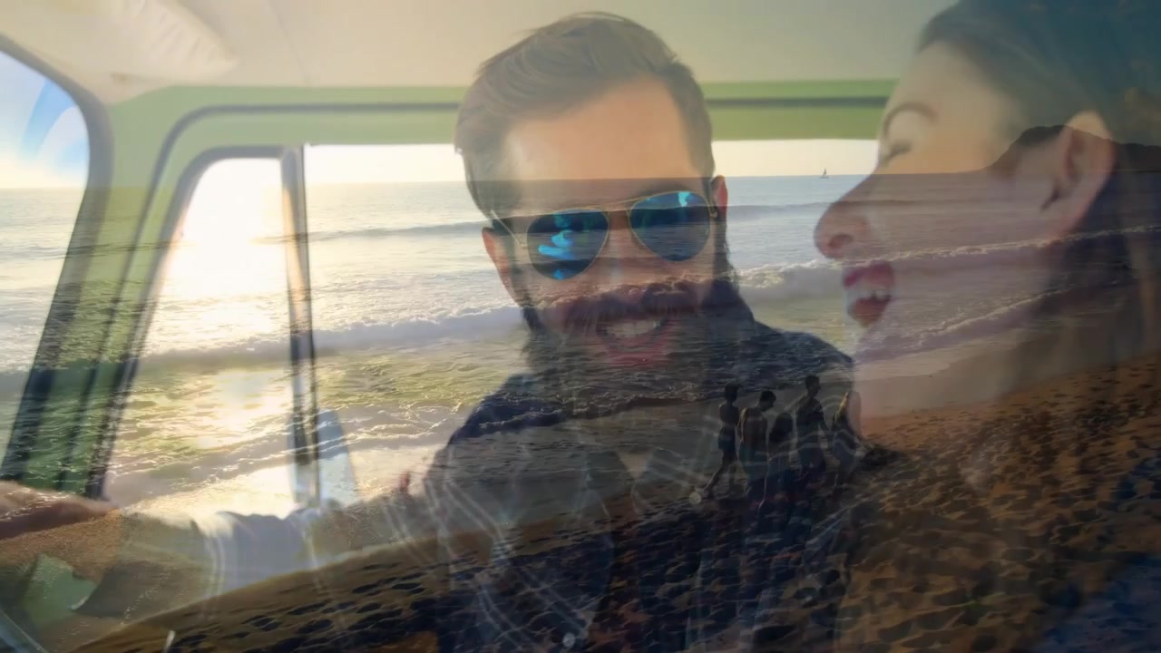 Uomo che guida e sorride, donna vivace che si appoggia e ride, onde dell'oceano che incorniciano un'atmosfera di viaggio.