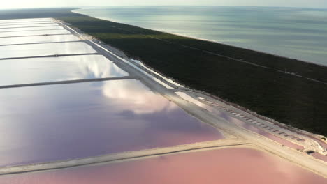estanques de sal rosas y istmos rectos de hierba a lo largo de la costa del océano