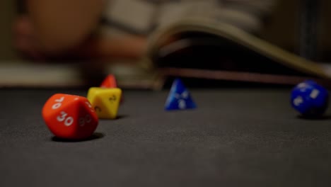 Throwing-role-playing-colorful-dices-on-black-surface,-slow-motion