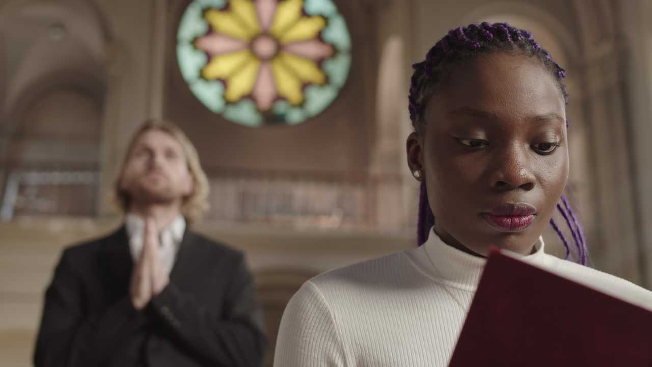 Two Diverse Parishioners Praying in Christian Church