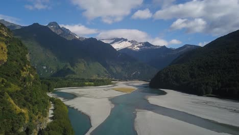descending pedestal drone shot of a melting river in a large valley at mount aspiring national park new zealand