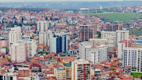 kosovo capital in autumn seen from reverse aerial flight, dense urban growth