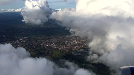 passenger view from aircraft over uk with large voluminous clouds, handheld