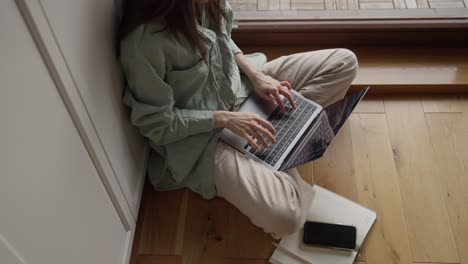 mujer trabajando en una computadora portátil en casa