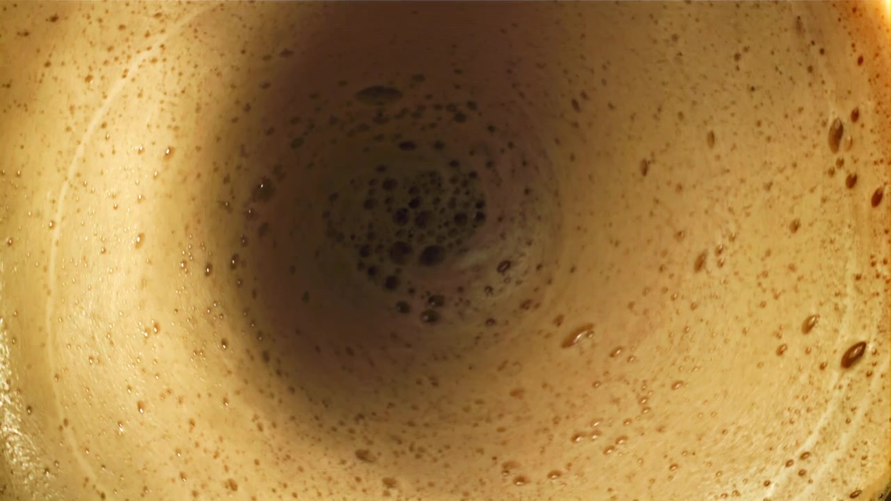 Primo piano di schiuma di caffè che turbina in movimento circolare