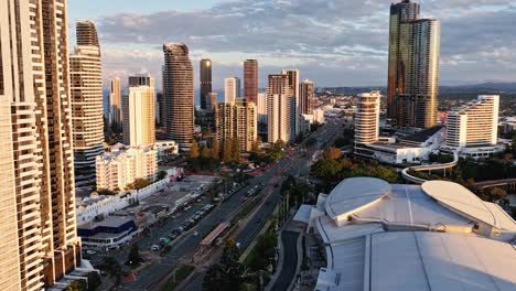 drone captures dynamic cityscape of gold coast, australia, highlighting skyscrapers and traffic in warm sunset lighting