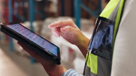 mujer usando una tableta para administrar el inventario en un almacén