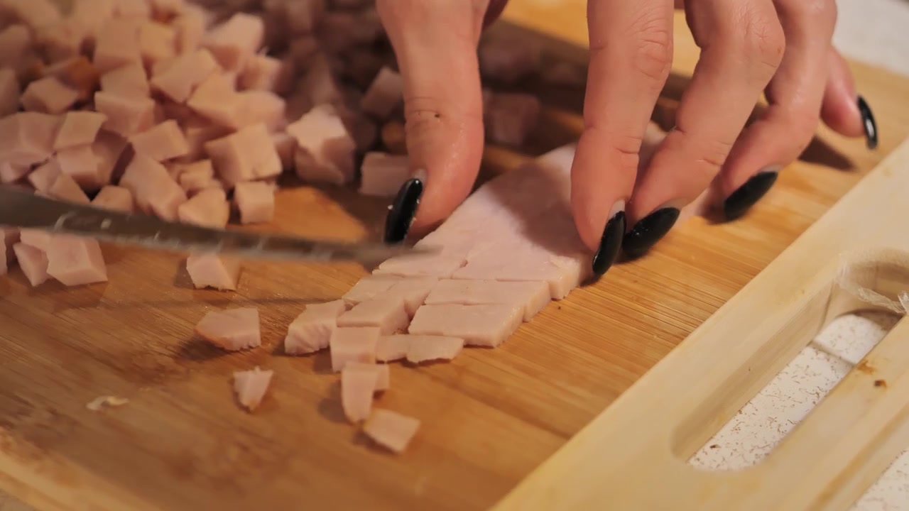 Ham die dun wordt gesneden op een houten plank, ter voorbereiding op het koken. 4K.