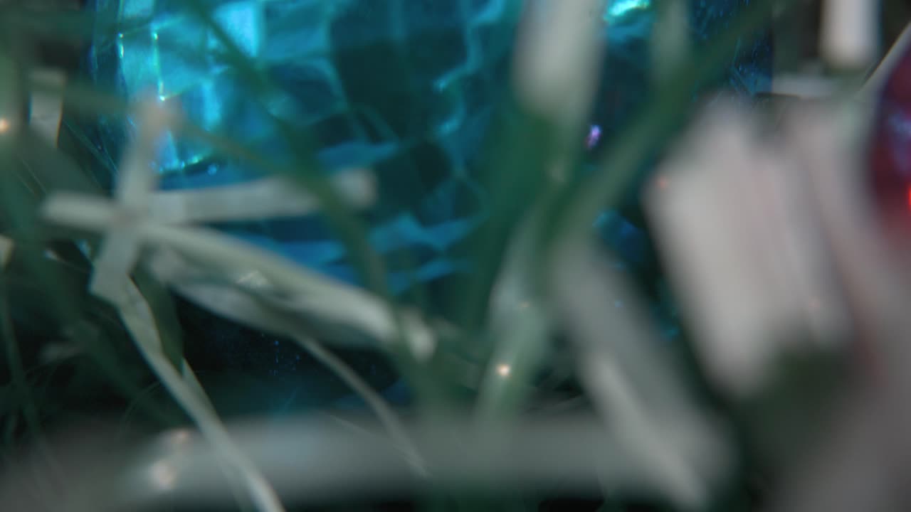 decoración de navidad, adornos de cristal coloridos bolas azules y verdes, año nuevo decorado, luces brillantes, cinematográfico de primer plano macro tilt up video 4k, hermosa profundidad de campo, luz bokeh