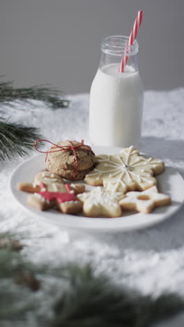 vertical video of bottle of milk, cookies with copy space on snow background