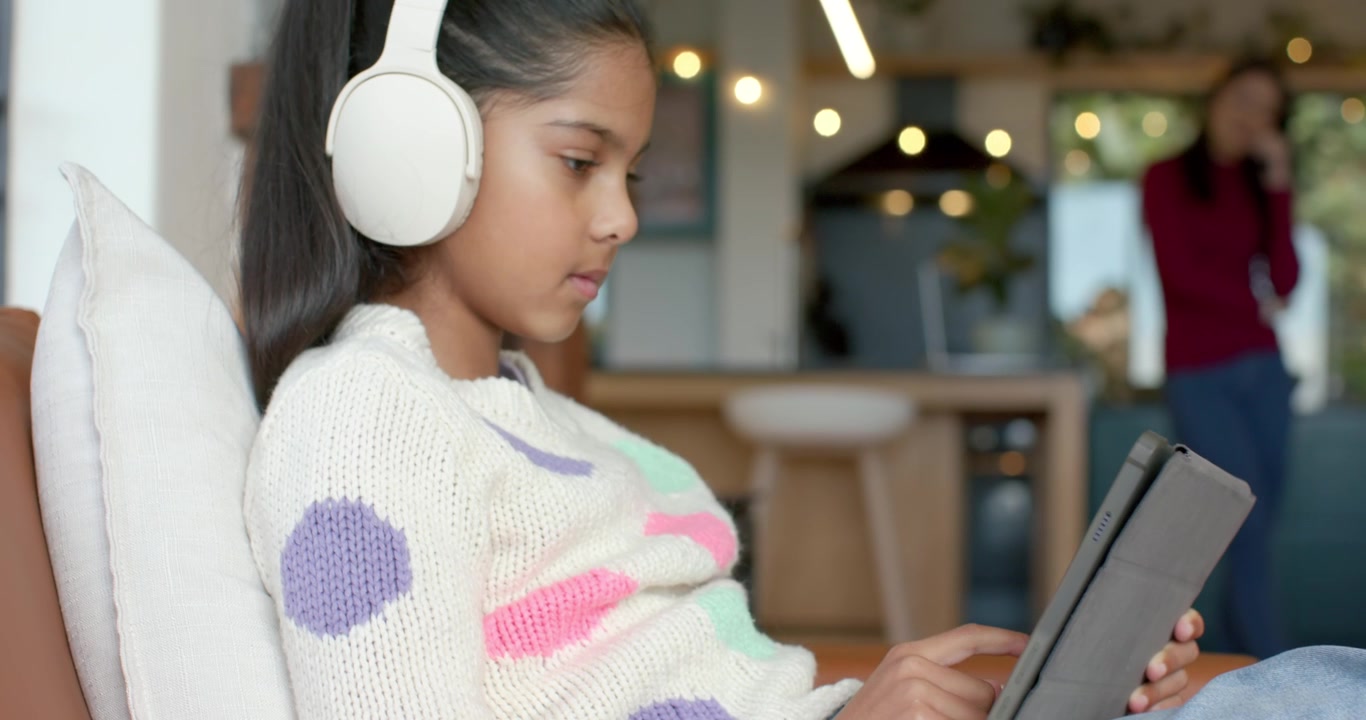 Young Girl Using Tablet with Headphones at Home