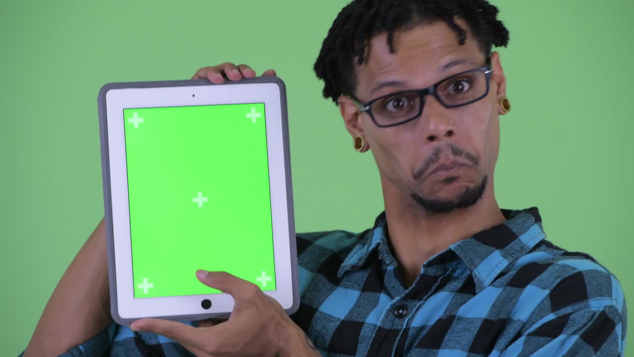 행복한 젊은 잘생긴 아프리카 스터 남자가 디지털 태블릿을 보여줍니다.