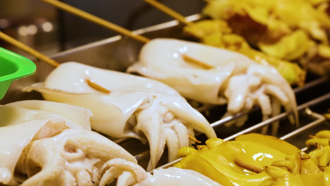 Des brochettes de calmar grillées dans un marché nocturne