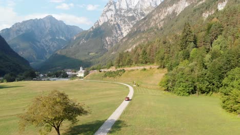 aerial-car-driving-on-scenic-road-in-Slovenia-in-summer,-Log-pod-mangrtom-in-Soca-valley