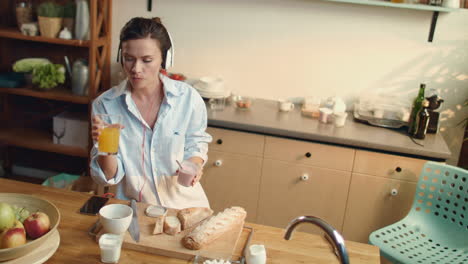 girl eating yogurt baguette grapes in kitchen. woman drinking orange juice.