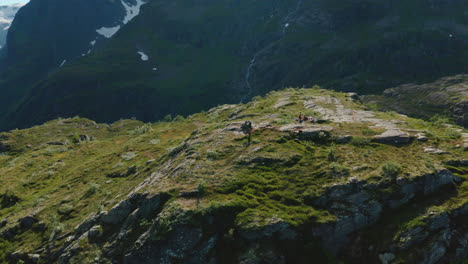 bird's eye view of the mountaineers at the clifftop and the alpine mountain range in olden, norway