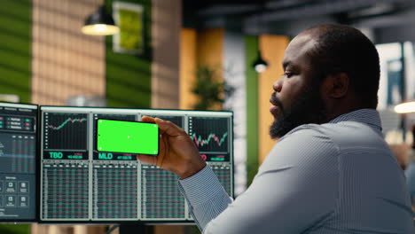 prop firm worker learns trading strategies from video on green screen phone
