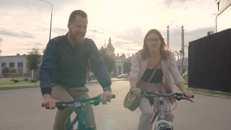 couple cycling in city at sunset