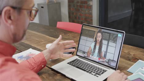 hombre de negocios caucásico en una videollamada con una colega caucásica en la pantalla
