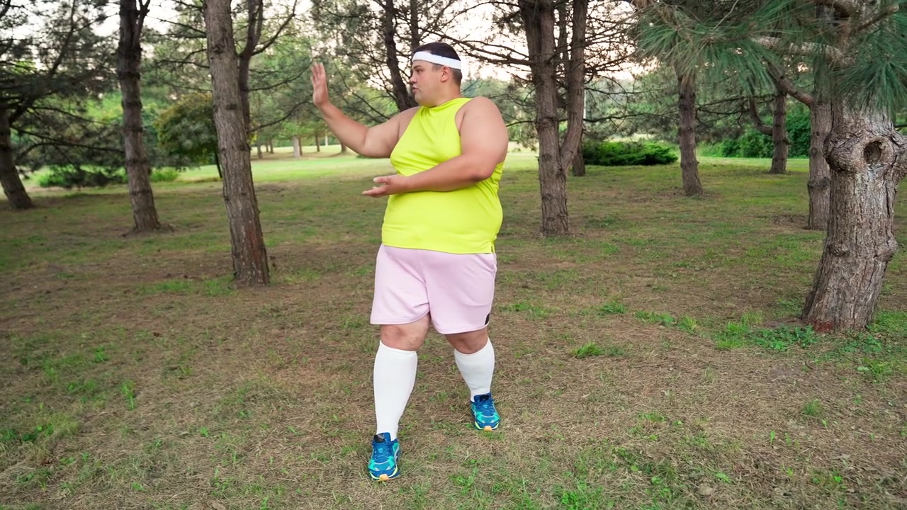 Uomo in sovrappeso che pratica Tai Chi in un parco verde
