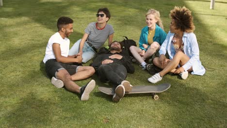 lounging friends on meadow in park