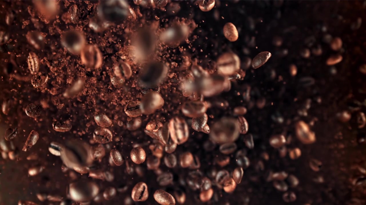 Ristede kaffebønner og malt kaffe faller i sakte film