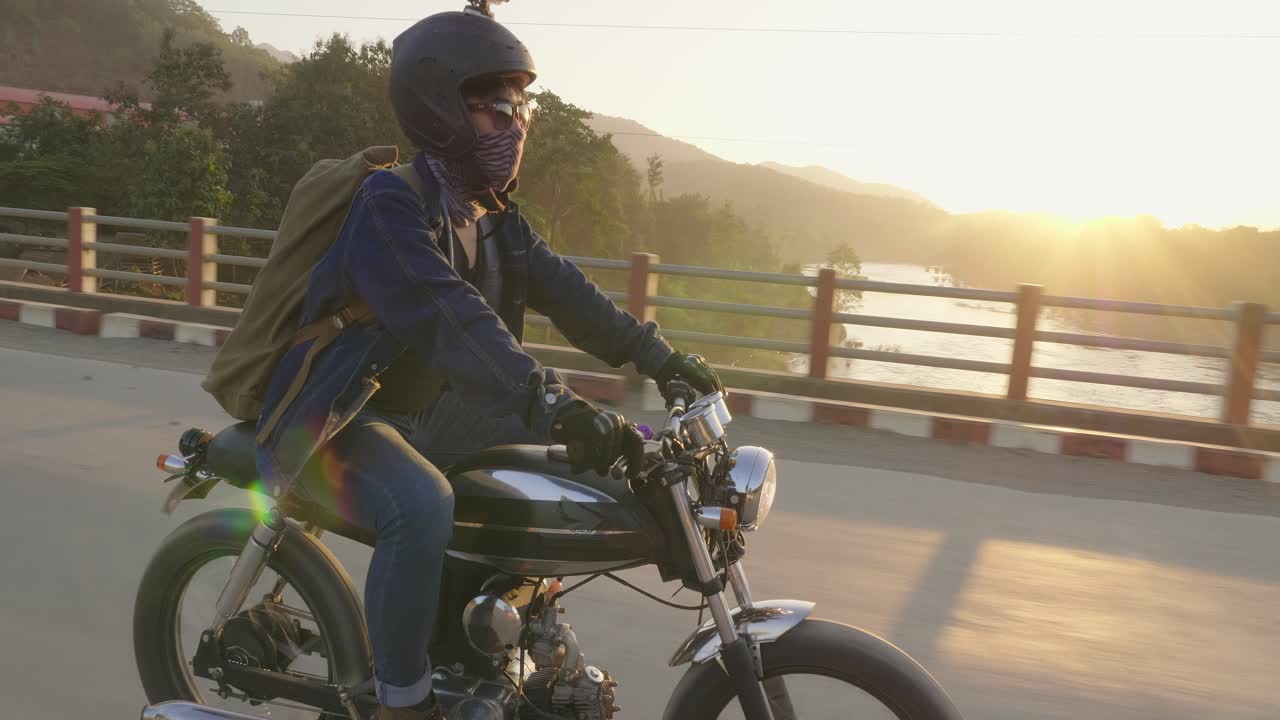 Motorcycle rider on a bridge at sunset
