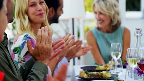 Friends-applauding-woman-while-having-meal