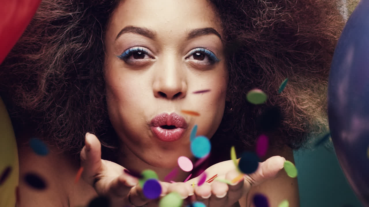 hermosa mujer hispana soplando confeti de colores en cámara lenta fondo de globo multicolor - dragón épico rojo