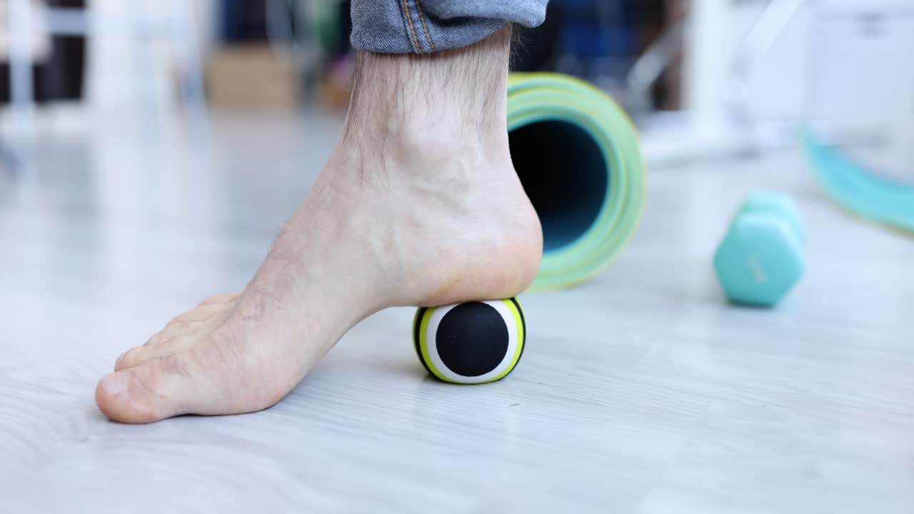 Foot massage with massage ball for plantar fasciitis relief