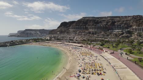 aerial view of tourists on a sandy amadores beach, summer relaxation in the resort