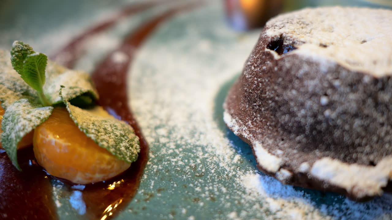Chocolate lava cake with ice cream and orange decoration in a restaurant