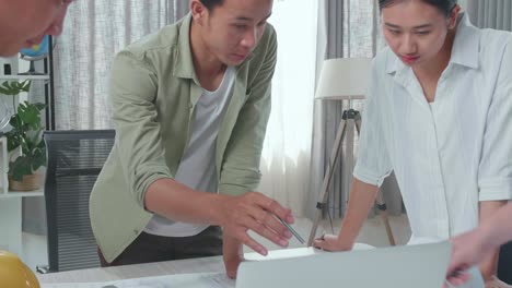 group of asian engineers discuss about work on laptop at the office