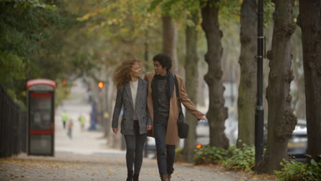 romantic couple walk on fall street in city in slow motion