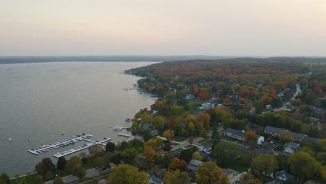 alta vista aérea de casas suburbanas frente al lago durante el pintoresco follaje de otoño en el lago de ginebra, wisconsin, estados unidos