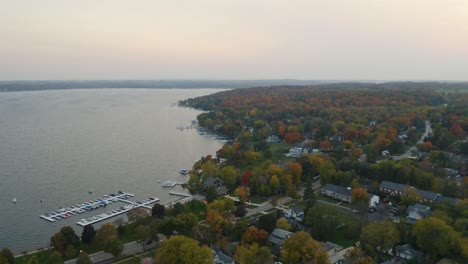 alta vista aérea de casas suburbanas frente al lago durante el pintoresco follaje de otoño en el lago de ginebra, wisconsin, estados unidos