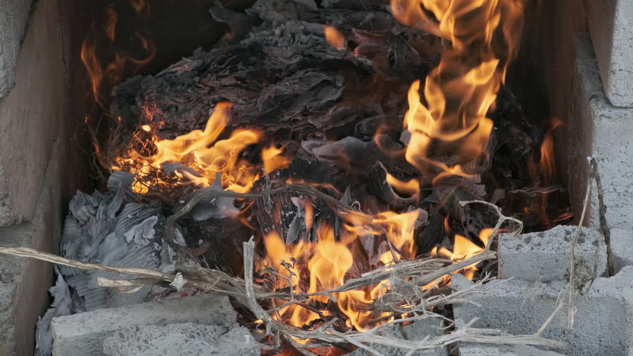 Paper and weeds burning in bonfire close up
