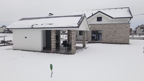 Antena-De-Una-Casa-Inteligente-Moderna-Cubierta-De-Nieve-Con-Panel-Solar-Instalado-En-Una-Casa-En-La-Azotea-En-Distritos-Residenciales,-Apagón-Y-Tormenta-De-Nieve-Concepto-De-Temporada-Invernal