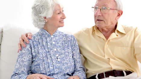 una pareja de ancianos hablando en voz baja.