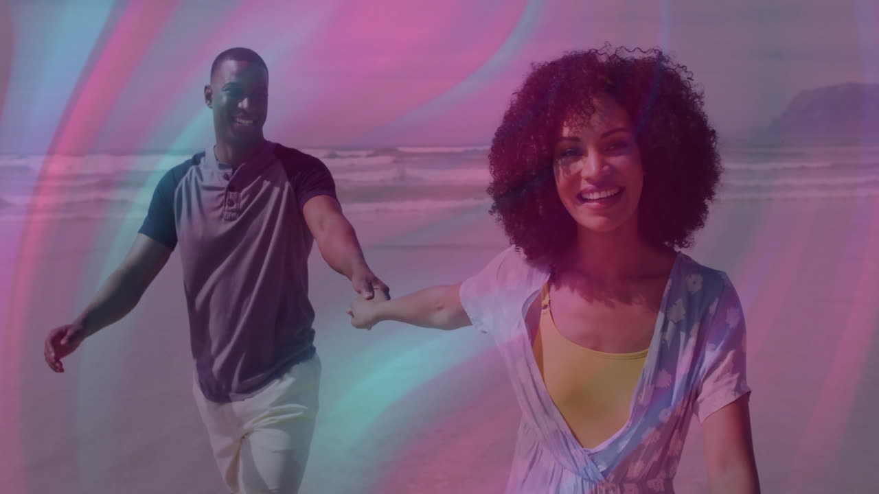 Smiling couple holding hands walking on beach with colorful overlay animation