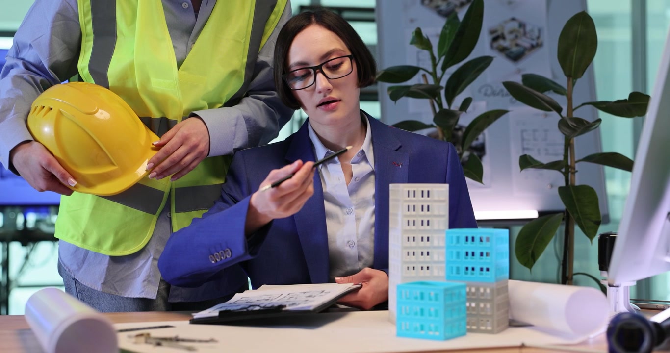 Empresária discute etapas de construção com construtor.