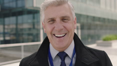 portrait-of-successful-senior-businessman-ceo-laughing-cheerful-at-camera-wearing-suit-in-urban-office-building-background